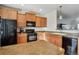 Kitchen with light wood cabinets, black appliances, and a breakfast bar at 985 Burning Bush Pt, Monument, CO 80132