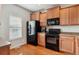 Kitchen with light wood cabinets and black appliances at 985 Burning Bush Pt, Monument, CO 80132