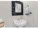 Charming powder room featuring a pedestal sink with decorative mirror and fixtures at 26741 E Arbor Dr, Aurora, CO 80016