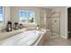 Modern bathroom featuring a soaking tub, shower, and bright natural light at 26741 E Arbor Dr, Aurora, CO 80016