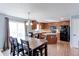 Eat-in kitchen featuring warm wood cabinets, stainless steel appliances, and space for dining at 11537 Macon St, Commerce City, CO 80640