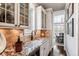 Stylish bar area with granite countertops, wine storage, and glass cabinets for entertaining at 639 S Williams St, Denver, CO 80209