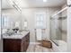 Bright bathroom with dual sinks, granite countertops, and a glass-enclosed shower/tub at 639 S Williams St, Denver, CO 80209