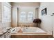 Elegant soaking tub with tile surround, shutters and great natural light at 639 S Williams St, Denver, CO 80209