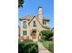 Charming stone home with blue-trimmed windows, a stone chimney, and manicured landscaping at 639 S Williams St, Denver, CO 80209