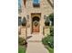 Inviting stone entryway featuring an arched wood door with decorative wreath and matching sconces at 639 S Williams St, Denver, CO 80209