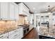 Modern kitchen features white cabinets, granite countertops, stainless steel appliances, and dark wood flooring at 639 S Williams St, Denver, CO 80209