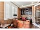 Home office with custom built-ins, a large wooden desk, and natural light from shuttered window at 639 S Williams St, Denver, CO 80209