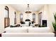 Bright living room with hardwood floors, white sofas, decorative chandelier, arched windows and fireplace at 2435 S Milwaukee St, Denver, CO 80210
