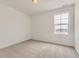 Minimalist bedroom featuring carpet floors, white walls, and a window offering natural light at 8867 Waterleaf Ln, Littleton, CO 80125
