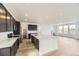 Spacious kitchen with an island, stainless steel appliances, dark cabinets, and bright natural light at 8867 Waterleaf Ln, Littleton, CO 80125
