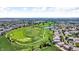 Aerial view showcasing a neighborhood near a golf course and a serene pond at 5558 Malta St, Denver, CO 80249