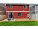 Backyard with a patio seating area, rock landscaping, small grass area, and red wood-panel siding at 5558 Malta St, Denver, CO 80249