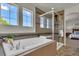 Bathroom features a luxurious bathtub, a glass-enclosed shower, and modern fixtures at 5558 Malta St, Denver, CO 80249