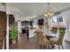 Dining area features a glass-top table with woven chairs, a modern chandelier, and sliding glass doors at 5558 Malta St, Denver, CO 80249