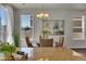 Elegant dining area with a chandelier, woven chairs, and a view of the kitchen island at 5558 Malta St, Denver, CO 80249