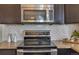 The kitchen features stainless steel appliances, dark cabinets, and sleek granite counters for a modern aesthetic at 5558 Malta St, Denver, CO 80249