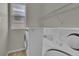 Bright laundry room with modern washer and dryer, plus storage shelf at 5558 Malta St, Denver, CO 80249
