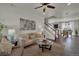 Bright living room with neutral-toned furniture, a ceiling fan, and hardwood flooring leading to the dining area at 5558 Malta St, Denver, CO 80249