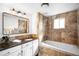 A renovated bathroom with tiled walls, bathtub, granite countertops and updated vanity at 404 S Jasmine St, Denver, CO 80224