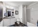 This bathroom features a modern vanity with countertop sink, tile floors, and a shower-tub combo at 5280 Genoa St, Denver, CO 80249
