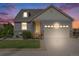 Charming home featuring stone accents and manicured lawn at dusk at 5280 Genoa St, Denver, CO 80249