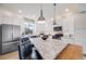 Bright kitchen features granite counters, stainless steel appliances, and stylish pendant lighting at 5280 Genoa St, Denver, CO 80249