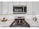 Close up on kitchen featuring granite counters, stainless appliances and mosaic tile backsplash at 5280 Genoa St, Denver, CO 80249