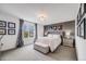 This main bedroom features a tufted headboard, upholstered bench, and a large window with lots of light at 5280 Genoa St, Denver, CO 80249
