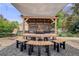 Inviting outdoor kitchen features a built-in grill, bar seating, dining area, and stylish pergola with decorative shade at 5280 Genoa St, Denver, CO 80249