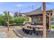 Inviting outdoor kitchen features a built-in grill, bar seating, dining area, and stylish pergola with decorative shade at 5280 Genoa St, Denver, CO 80249
