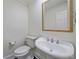 Elegant powder room featuring a pedestal sink, stylish mirror, and classic fixtures at 5227 S Geneva St, Englewood, CO 80111