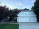 Charming two-story home featuring an attached three-car garage, mature trees, and professionally landscaped front yard at 5227 S Geneva St, Englewood, CO 80111