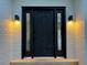 Contemporary front door with sidelights and sconces on a painted brick exterior at 5227 S Geneva St, Englewood, CO 80111