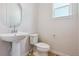 Neat half-bathroom with sleek pedestal sink, modern fixtures, and a separate toilet at 13765 Emerald Lake St, Parker, CO 80138