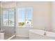 Bright bathroom with a glass shower, soaking tub, and window views at 13765 Emerald Lake St, Parker, CO 80138