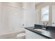 Full bathroom featuring white tile shower over tub and a black countertop vanity at 13765 Emerald Lake St, Parker, CO 80138