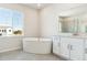 Bright bathroom featuring a soaking tub, dual sink vanity, and window views at 13765 Emerald Lake St, Parker, CO 80138