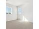 Bright, empty bedroom with carpet, large windows and neutral walls perfect to make it your own at 13765 Emerald Lake St, Parker, CO 80138