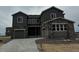 Charming two-story home featuring a stone and gray facade, two-car garage, and well-manicured landscaping at 13765 Emerald Lake St, Parker, CO 80138
