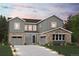 Striking two-story home with stone accents, a well-manicured lawn, and gray siding at 13765 Emerald Lake St, Parker, CO 80138