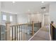 Second floor hallway overlooking the entryway with wooden and black railings at 13765 Emerald Lake St, Parker, CO 80138