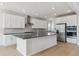 Bright kitchen boasts stainless steel appliances, white cabinets, and a spacious center island at 13765 Emerald Lake St, Parker, CO 80138