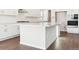 Bright kitchen featuring a large white island, stainless steel appliances, and wood flooring at 13765 Emerald Lake St, Parker, CO 80138