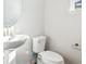 Bright powder room featuring a pedestal sink and modern toilet at 13765 Emerald Lake St, Parker, CO 80138