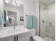 Bright bathroom featuring a glass-enclosed shower, modern vanity, and stylish towel racks at 5469 S Curtice St # E, Littleton, CO 80120