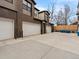 Multiple car garages with concrete driveway, brick accents, and modern architecture at 5469 S Curtice St # E, Littleton, CO 80120