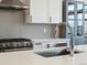 Close-up of stainless steel sink, gas range, and cabinetry in modern kitchen at 5469 S Curtice St # E, Littleton, CO 80120