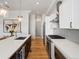A gourmet kitchen features stainless steel appliances, white cabinets, quartz countertops, and hardwood floors at 5469 S Curtice St # E, Littleton, CO 80120