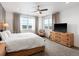 Cozy main bedroom with hardwood floors, two windows, neutral-colored decor, and ceiling fan at 5469 S Curtice St # E, Littleton, CO 80120